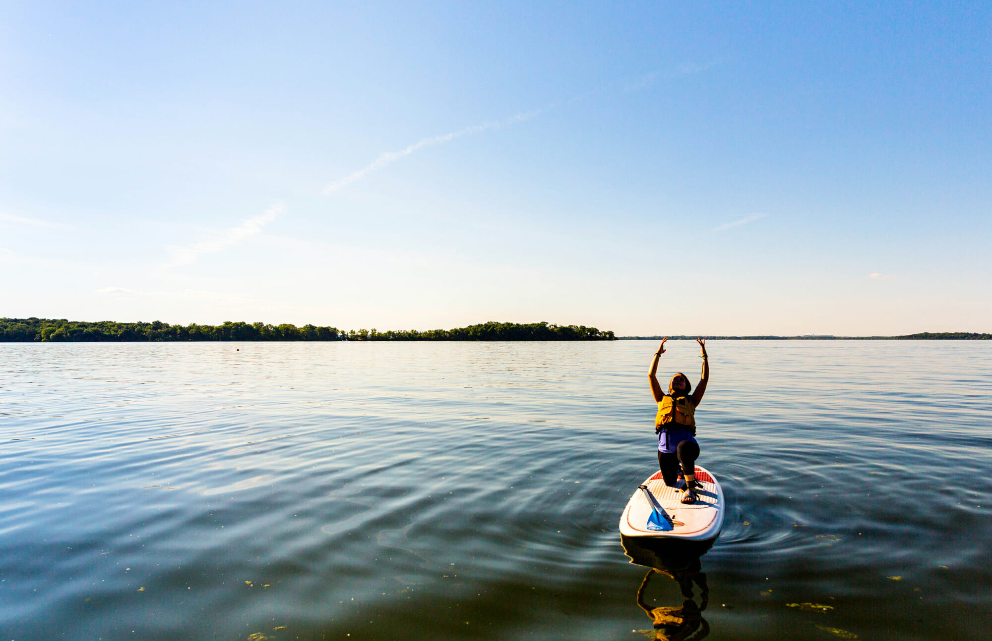 paddle board yoga person on a calm lake