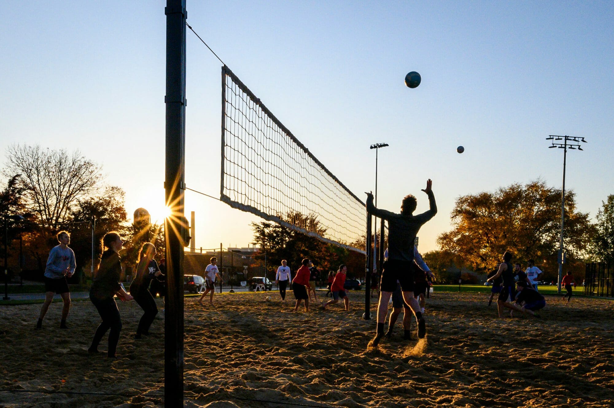 Students playing volleyball at dusk